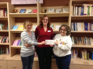 Samantha (L) and her mother Ronnie (R) present our development director Amber with a check from their event.